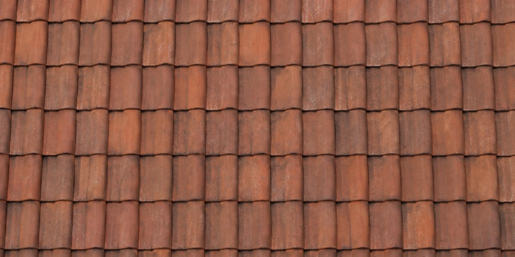 Dach kryty czerwoną dachówką ceramiczną, zbliżenie na rzędy dachówek